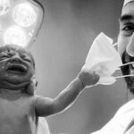 Covid-19, neonato tira via la mascherina al medico: la foto della speranza